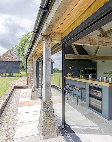 Blick von aussen auf Küche und Garten mit einem Gartenhäuschen